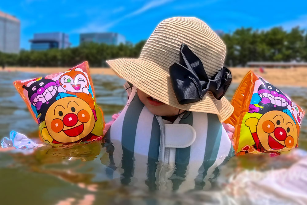 スリーコインズのライフジャケットを着用して海で遊ぶ子供